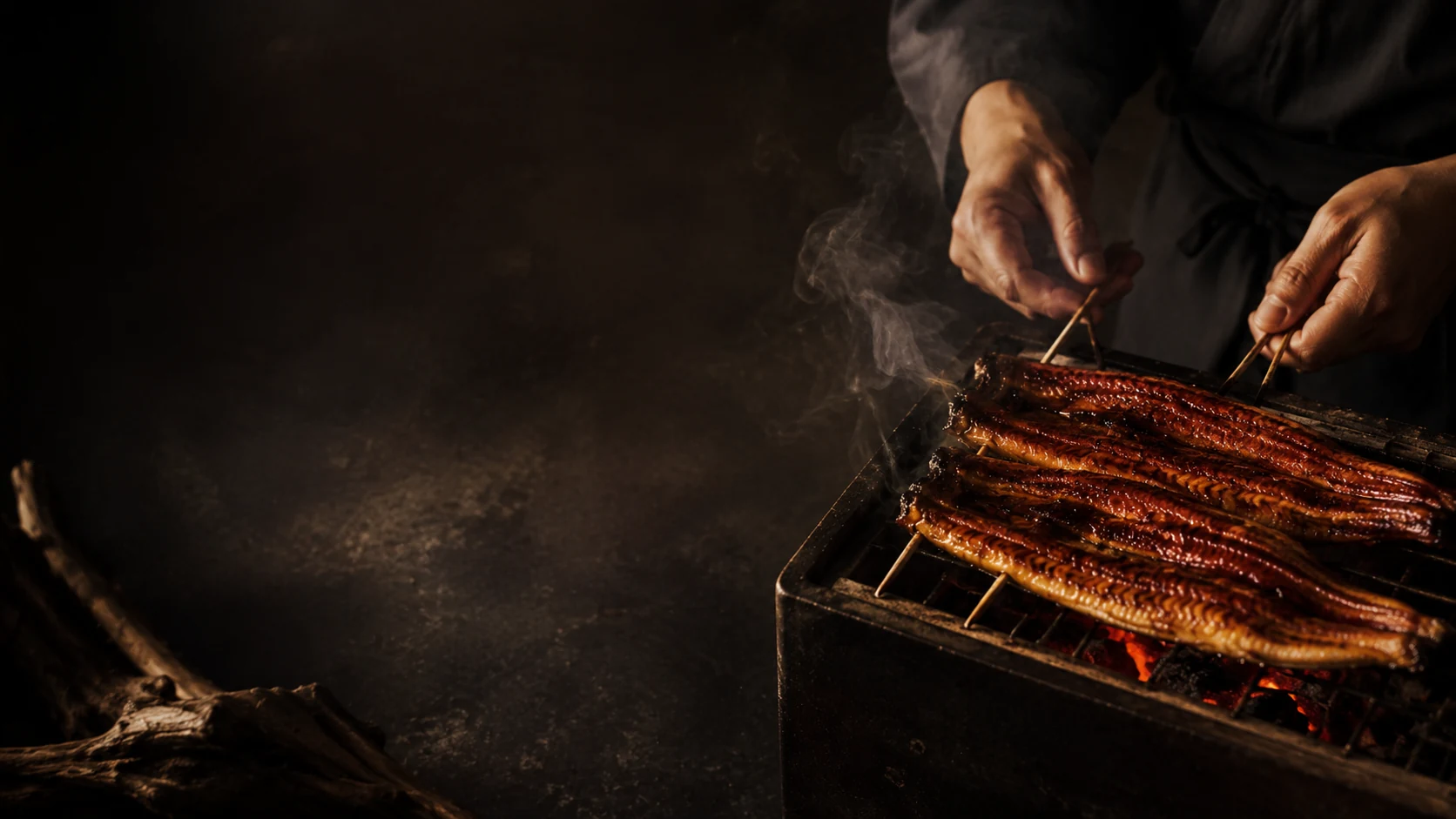 炭火でうなぎを焼き上げる職人の手元